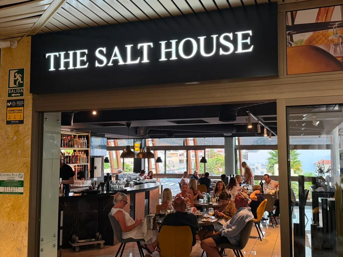 The lit sign over the door, with guests dining inside